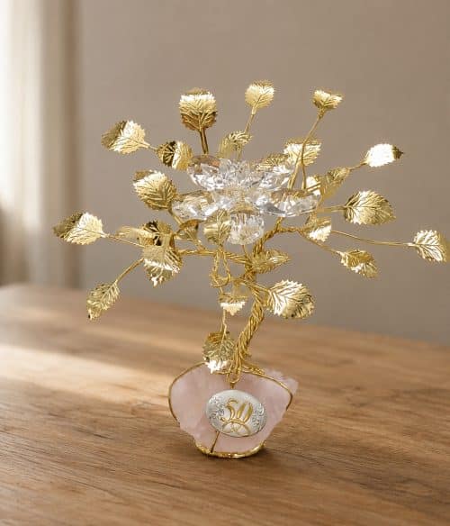 Gold-toned decorative tree sculpture with crystal leaves on a pink stone base, commemorating a 50th anniversary.